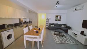 a kitchen and a living room with a table and a couch at STAY Tranquil Terrace in Aglantzia