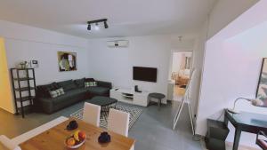 uma sala de estar com um sofá e uma mesa em STAY Tranquil Terrace em Aglantzia