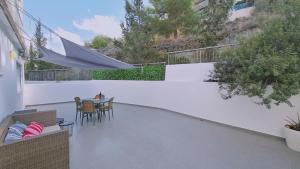 un patio con mesa, sillas y sombrilla en STAY Tranquil Terrace, en Aglantzia