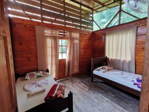 a bedroom with two beds in a wooden house at Ecogreen Hotel - San Cipriano in San Cipriano