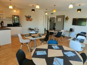 a room with tables and chairs and a kitchen at Domaine de la Barbinais in Saint Malo