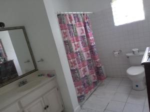 a bathroom with a shower curtain and a toilet at OCEANView in Montego Bay