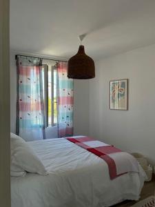 sypialnia z białym łóżkiem i oknem w obiekcie Charmante maison de village . Saint remy de pce w mieście Saint-Rémy-de-Provence