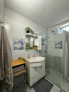 a bathroom with a sink and a shower at Kakavanen’s Sea View apartment in Balchik
