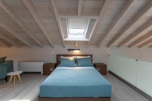 ein Schlafzimmer mit einem großen Bett und einem Dachfenster in der Unterkunft Akti Vigla Apartments in Mytilini
