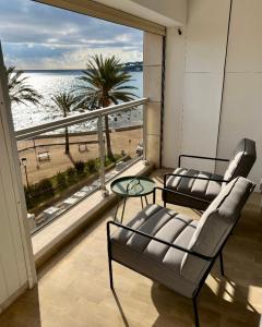 a balcony with two chairs and a view of the beach at Antibes sea view near Ilette - Sleeps 4 - Parking in Antibes