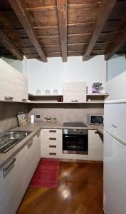 a kitchen with white appliances and a wooden ceiling at L’incontro in Bergamo