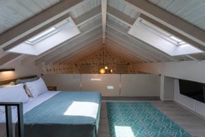 a bedroom with a bed and two skylights at Akti Vigla Apartments in Mytilini