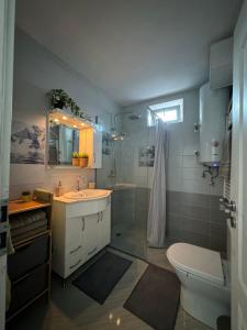 a bathroom with a sink and a shower and a toilet at Kakavanen’s Sea View apartment in Balchik