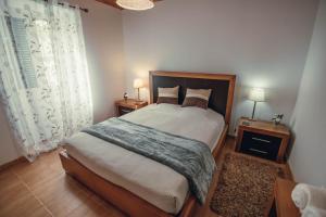 a bedroom with a large bed and two night stands at SHR House in Porto Formoso