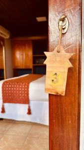 a wooden door with a star on it next to a bed at Pousada Pedras Secas in Fernando de Noronha