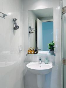 een witte badkamer met een wastafel en een spiegel bij Samhomes - Luxury apartment at Masteri An Phu in Ho Chi Minh-stad