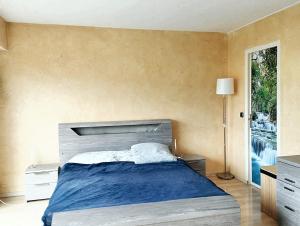 ein Schlafzimmer mit einem großen Bett mit einer blauen Decke in der Unterkunft Maison de 5 chambres avec jardin clos et wifi a Maurepas in Maurepas