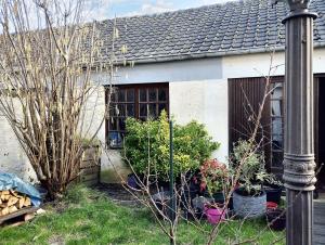 a house with potted plants in front of it at Maison de 5 chambres avec jardin clos et wifi a Maurepas in Maurepas