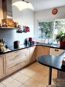 a kitchen with a black counter top and a table at Maison de 5 chambres avec jardin clos et wifi a Maurepas in Maurepas