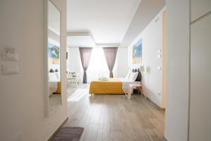 una camera da letto con un letto e uno specchio di B&B WelcHome a Porto SantʼElpidio