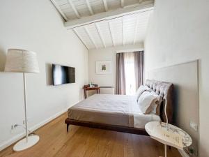 a white bedroom with a bed and a window at Suite Greve in Chianti in Greve in Chianti