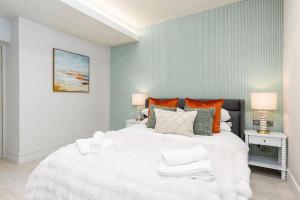 哈羅蓋特的住宿－Charming Granby Flat，卧室配有带橙色枕头的大型白色床