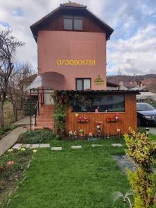 uma casa com um sinal ao lado dela em Casa Fabrizio em Călimăneşti