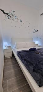 Barcelona, apartamento de 1 habitación في لوسبيتاليت دي يوبريغات: غرفة نوم مع سرير والطيور على الحائط