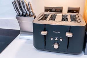 a toaster sitting on a counter next to a container of knives at Charming Granby Flat in Harrogate +26 photos