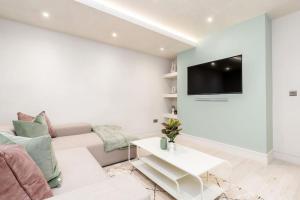 un soggiorno bianco con divano e TV di Charming Granby Flat a Harrogate