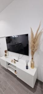 a white entertainment center with a flat screen tv at Barcelona, apartamento de 1 habitación in Hospitalet de Llobregat