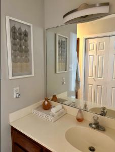 uma casa de banho com um lavatório e um espelho grande em Lakeside Motel, Cabins and RV em Kingston