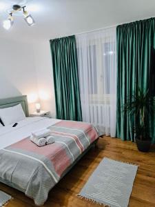a bedroom with a bed with green curtains at Iris Apartment in Piatra Neamţ