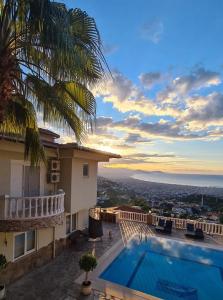 - une vue sur une maison avec une piscine dans l'établissement Уютная вилла с шикарным панорамным видом, à Alanya