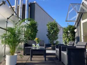a patio with chairs and tables and potted plants at Mango Living - Hideaway -, Dachterrasse, 77qm, 2 Schlafzimmer, 6 Personen, am Hauptbahnhof Rheydt in Mönchengladbach
