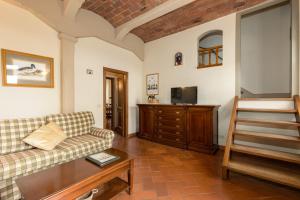 een woonkamer met een bank en een tafel bij Podere San Bartolo- Casa colonica 2 in Barberino di Val dʼElsa
