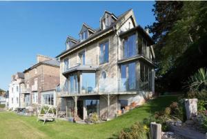 a large stone house with glass windows on a lawn at Captivating 7-Bed House in Bristol in Bristol