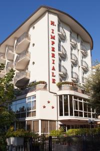 a hotel with a sign on the side of it at Hotel Imperiale in Cesenatico