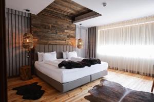 a bedroom with a large bed with two black pillows at HANUL BUCOVINEI in Câmpulung Moldovenesc