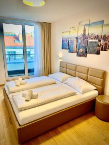ein Schlafzimmer mit zwei Betten und einem großen Fenster in der Unterkunft Apartments4you in Wien