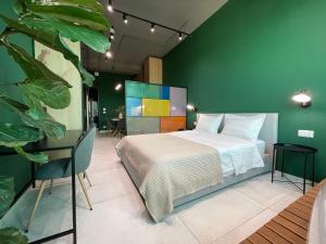 a bedroom with a bed and a green wall at Ambassador Skyline Apartments in Tirana