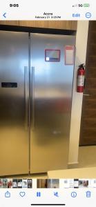 a stainless steel refrigerator in a kitchen at Kornialle in Accra