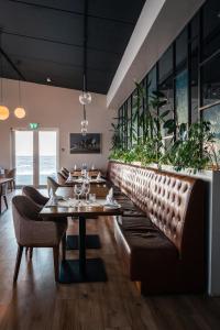 un ristorante con divano, tavoli e piante di Umi Hotel a Skogar