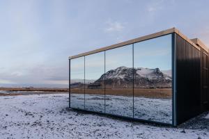 a glass building with a mountain in the background at Umi Hotel in Skogar