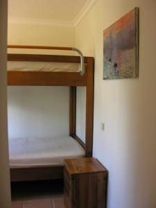 カストロ・マリンにあるRetur Algarve Beach Houseのベッドルーム1室(二段ベッド2組、木製テーブル付)