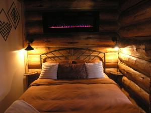 1 dormitorio con 1 cama con pared de madera en Boulder Mountain Guest Ranch en Boulder Town