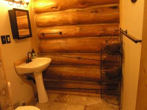 a bathroom with a wall made out of logs at Boulder Mountain Guest Ranch in Boulder Town