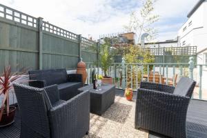 a patio with wicker chairs and a table at Tideway in Whitstable