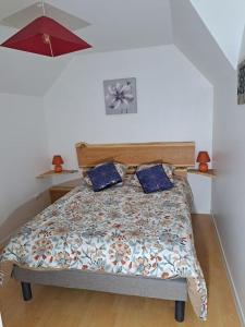 - un lit avec 2 oreillers bleus dans une chambre dans l'établissement APPARTEMENT BEAU SOLEIL, à La Bâtie-Neuve