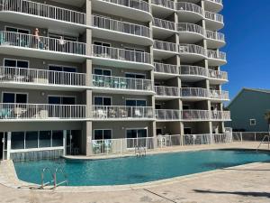 un gran edificio de apartamentos con piscina frente a él en Tradewinds 908, en Orange Beach