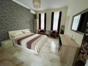 1 dormitorio con 1 cama, mesa y sillas en Villa DEA DORATA en Oradea