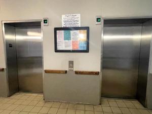 Dos ascensores metálicos con un cartel en la pared en Tradewinds 908, en Orange Beach