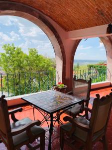 um pátio com uma mesa e cadeiras numa varanda em LA ERMITA "Antigua casa de Cantinflas" em San Miguel de Allende