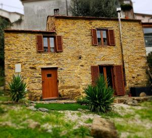 ein altes Steinhaus mit Holztür und Fenstern in der Unterkunft PampiHouse in Pampilhosa da Serra